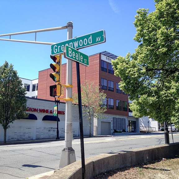 a street sign for greenwood ave and beale st is shown in front of a building.